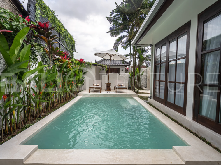 Tranquil outdoor pool area surrounded by greenery in a luxurious Bali property.