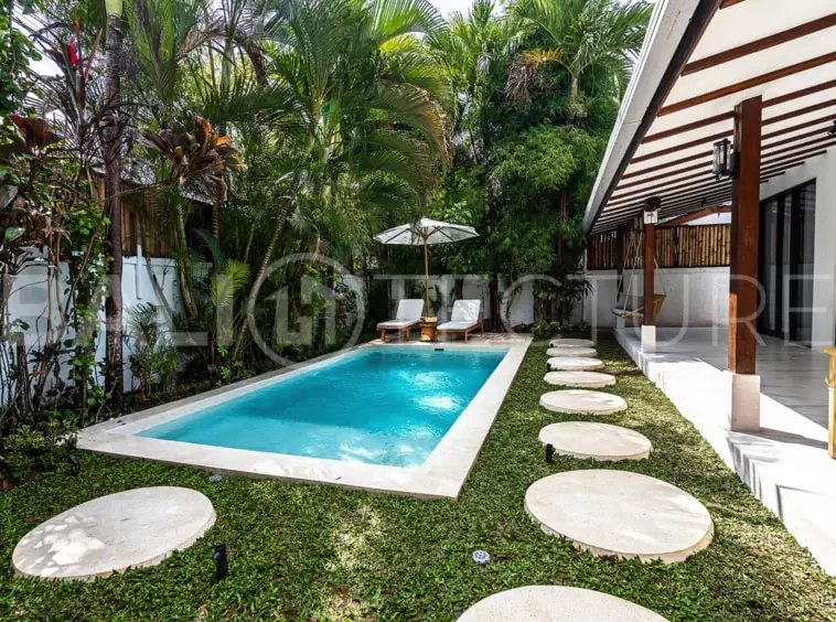 Tranquil outdoor pool area surrounded by greenery in a luxurious Bali property.