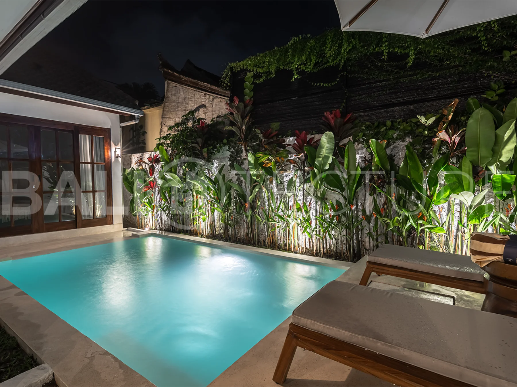 Tranquil outdoor pool area surrounded by greenery in a luxurious Bali property.