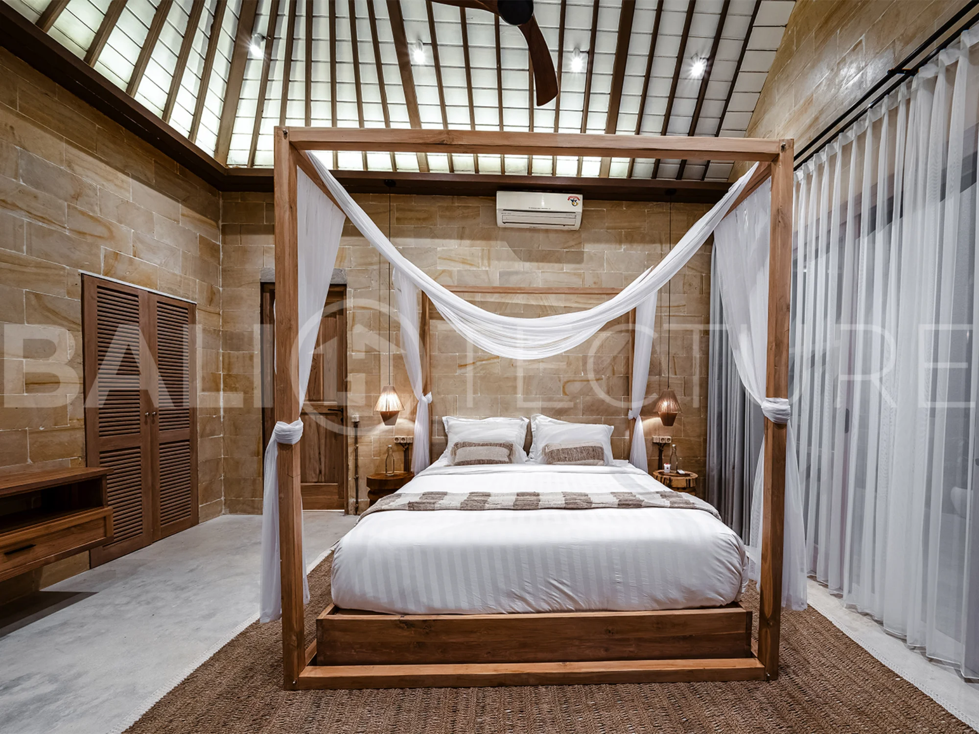 A cozy bedroom in a contemporary Ubud villa, offering comfort and views of lush tropical surroundings.