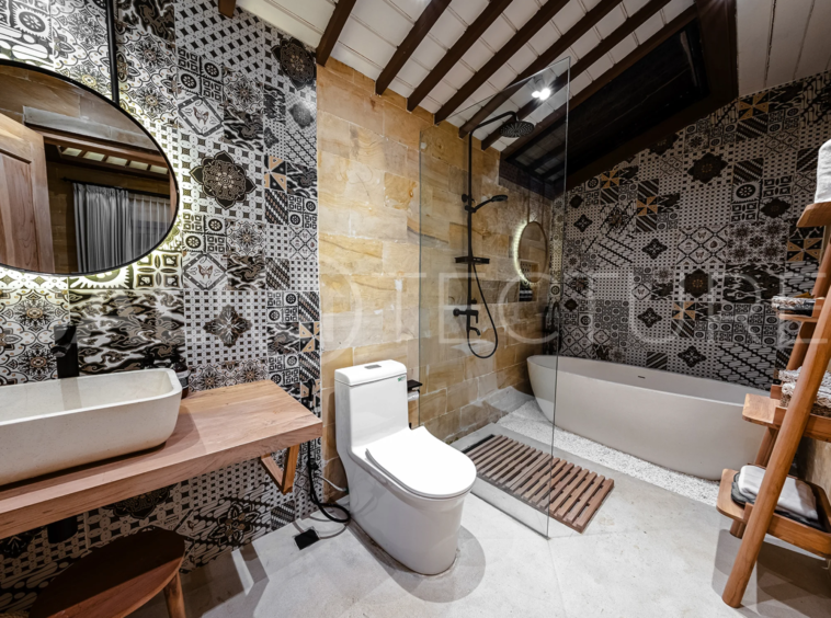 A cozy bedroom in a contemporary Ubud villa, offering comfort and views of lush tropical surroundings.