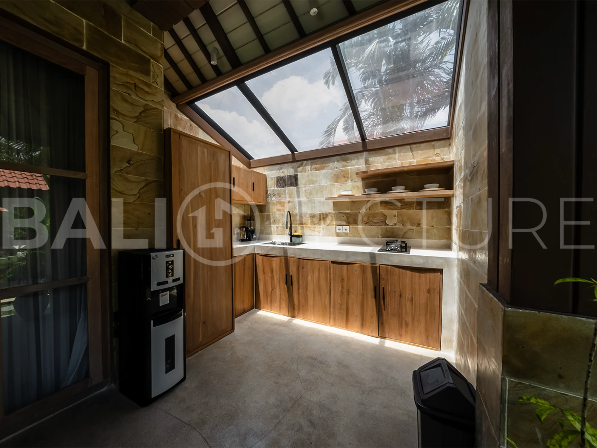 A cozy bedroom in a contemporary Ubud villa, offering comfort and views of lush tropical surroundings.