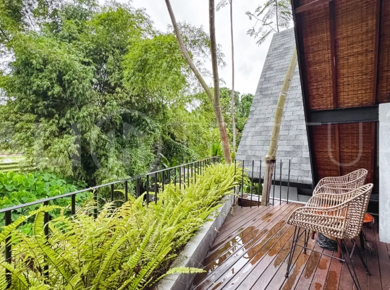 Luxury tropical-style 1-bedroom villa near Tanah Lot, Bali, featuring a two-story design with an open-plan living area, fully equipped kitchen, floor-to-ceiling glass windows, private swimming pool, river views, and lush tropical surroundings. The ensuite bedroom includes a private balcony overlooking the pool. Fully furnished and managed for rental income, this leasehold investment property is conveniently located near Tanah Lot Temple, Luna Beach Club, Nuanu City, beaches, restaurants, and cafés.
