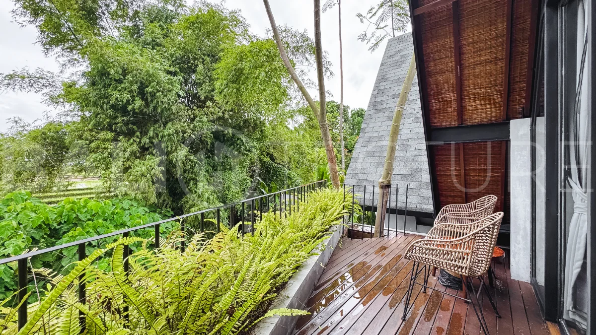 Luxury tropical-style 1-bedroom villa near Tanah Lot, Bali, featuring a two-story design with an open-plan living area, fully equipped kitchen, floor-to-ceiling glass windows, private swimming pool, river views, and lush tropical surroundings. The ensuite bedroom includes a private balcony overlooking the pool. Fully furnished and managed for rental income, this leasehold investment property is conveniently located near Tanah Lot Temple, Luna Beach Club, Nuanu City, beaches, restaurants, and cafés.