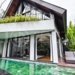 Luxury tropical-style 1-bedroom villa near Tanah Lot, Bali, featuring a two-story design with an open-plan living area, fully equipped kitchen, floor-to-ceiling glass windows, private swimming pool, river views, and lush tropical surroundings. The ensuite bedroom includes a private balcony overlooking the pool. Fully furnished and managed for rental income, this leasehold investment property is conveniently located near Tanah Lot Temple, Luna Beach Club, Nuanu City, beaches, restaurants, and cafés.