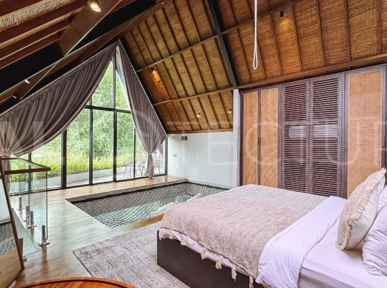 Luxury tropical-style 1-bedroom villa near Tanah Lot, Bali, featuring a two-story design with an open-plan living area, fully equipped kitchen, floor-to-ceiling glass windows, private swimming pool, river views, and lush tropical surroundings. The ensuite bedroom includes a private balcony overlooking the pool. Fully furnished and managed for rental income, this leasehold investment property is conveniently located near Tanah Lot Temple, Luna Beach Club, Nuanu City, beaches, restaurants, and cafés.