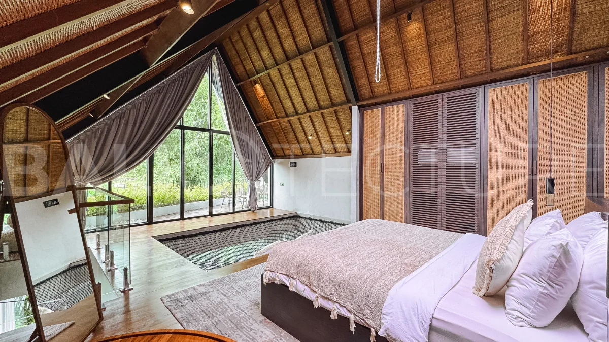 Luxury tropical-style 1-bedroom villa near Tanah Lot, Bali, featuring a two-story design with an open-plan living area, fully equipped kitchen, floor-to-ceiling glass windows, private swimming pool, river views, and lush tropical surroundings. The ensuite bedroom includes a private balcony overlooking the pool. Fully furnished and managed for rental income, this leasehold investment property is conveniently located near Tanah Lot Temple, Luna Beach Club, Nuanu City, beaches, restaurants, and cafés.