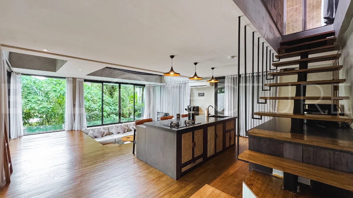 Luxury tropical-style 1-bedroom villa near Tanah Lot, Bali, featuring a two-story design with an open-plan living area, fully equipped kitchen, floor-to-ceiling glass windows, private swimming pool, river views, and lush tropical surroundings. The ensuite bedroom includes a private balcony overlooking the pool. Fully furnished and managed for rental income, this leasehold investment property is conveniently located near Tanah Lot Temple, Luna Beach Club, Nuanu City, beaches, restaurants, and cafés.