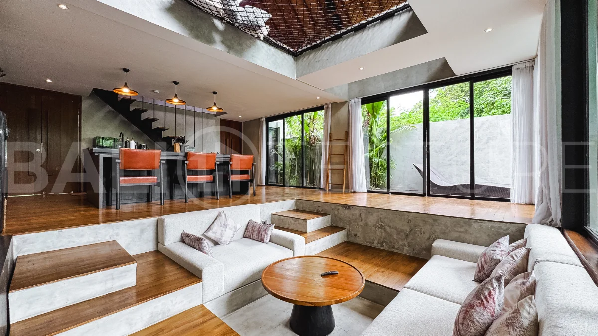 Luxury tropical-style 1-bedroom villa near Tanah Lot, Bali, featuring a two-story design with an open-plan living area, fully equipped kitchen, floor-to-ceiling glass windows, private swimming pool, river views, and lush tropical surroundings. The ensuite bedroom includes a private balcony overlooking the pool. Fully furnished and managed for rental income, this leasehold investment property is conveniently located near Tanah Lot Temple, Luna Beach Club, Nuanu City, beaches, restaurants, and cafés.