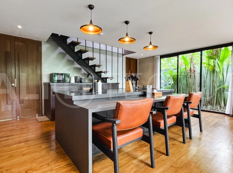 Luxury tropical-style 1-bedroom villa near Tanah Lot, Bali, featuring a two-story design with an open-plan living area, fully equipped kitchen, floor-to-ceiling glass windows, private swimming pool, river views, and lush tropical surroundings. The ensuite bedroom includes a private balcony overlooking the pool. Fully furnished and managed for rental income, this leasehold investment property is conveniently located near Tanah Lot Temple, Luna Beach Club, Nuanu City, beaches, restaurants, and cafés.
