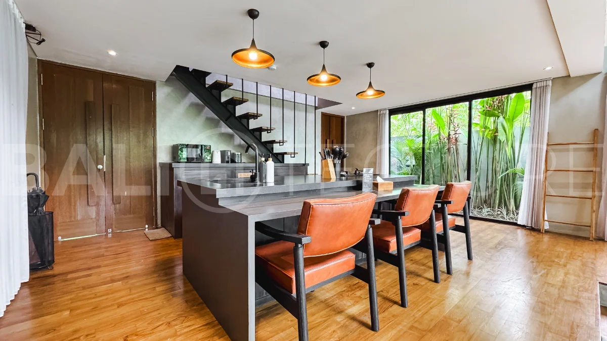 Luxury tropical-style 1-bedroom villa near Tanah Lot, Bali, featuring a two-story design with an open-plan living area, fully equipped kitchen, floor-to-ceiling glass windows, private swimming pool, river views, and lush tropical surroundings. The ensuite bedroom includes a private balcony overlooking the pool. Fully furnished and managed for rental income, this leasehold investment property is conveniently located near Tanah Lot Temple, Luna Beach Club, Nuanu City, beaches, restaurants, and cafés.