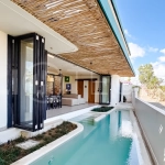 Brand new 3-bedroom tropical villa in Pecatu, Uluwatu featuring contemporary architecture, elegant natural finishes, and panoramic ocean views. The property includes three ensuite bedrooms, an enclosed living and dining area, a fully enclosed kitchen, a private 6 x 2 meter swimming pool, landscaped garden, balcony, and a rooftop terrace overlooking the ocean. Set on 204 m² of land with a 220 m² two-story building, the fully furnished villa is scheduled for completion in 2026 and is available under freehold and leasehold ownership in a prime tourism area.