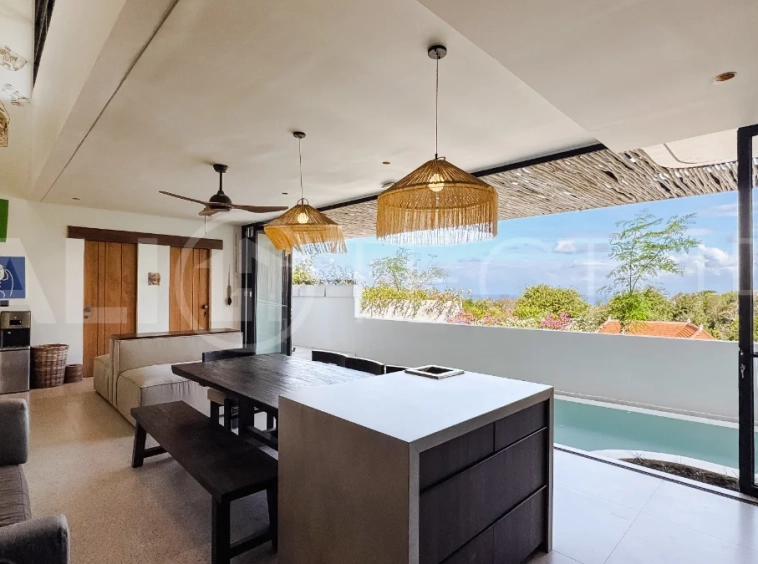Brand new 3-bedroom tropical villa in Pecatu, Uluwatu featuring contemporary architecture, elegant natural finishes, and panoramic ocean views. The property includes three ensuite bedrooms, an enclosed living and dining area, a fully enclosed kitchen, a private 6 x 2 meter swimming pool, landscaped garden, balcony, and a rooftop terrace overlooking the ocean. Set on 204 m² of land with a 220 m² two-story building, the fully furnished villa is scheduled for completion in 2026 and is available under freehold and leasehold ownership in a prime tourism area.