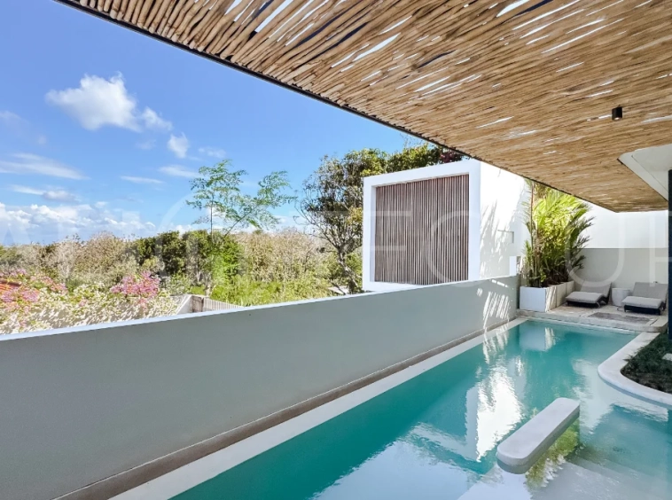 Brand new 3-bedroom tropical villa in Pecatu, Uluwatu featuring contemporary architecture, elegant natural finishes, and panoramic ocean views. The property includes three ensuite bedrooms, an enclosed living and dining area, a fully enclosed kitchen, a private 6 x 2 meter swimming pool, landscaped garden, balcony, and a rooftop terrace overlooking the ocean. Set on 204 m² of land with a 220 m² two-story building, the fully furnished villa is scheduled for completion in 2026 and is available under freehold and leasehold ownership in a prime tourism area.