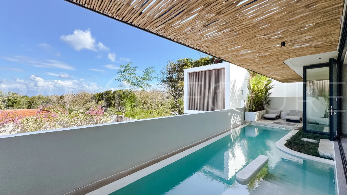 Brand new 3-bedroom tropical villa in Pecatu, Uluwatu featuring contemporary architecture, elegant natural finishes, and panoramic ocean views. The property includes three ensuite bedrooms, an enclosed living and dining area, a fully enclosed kitchen, a private 6 x 2 meter swimming pool, landscaped garden, balcony, and a rooftop terrace overlooking the ocean. Set on 204 m² of land with a 220 m² two-story building, the fully furnished villa is scheduled for completion in 2026 and is available under freehold and leasehold ownership in a prime tourism area.
