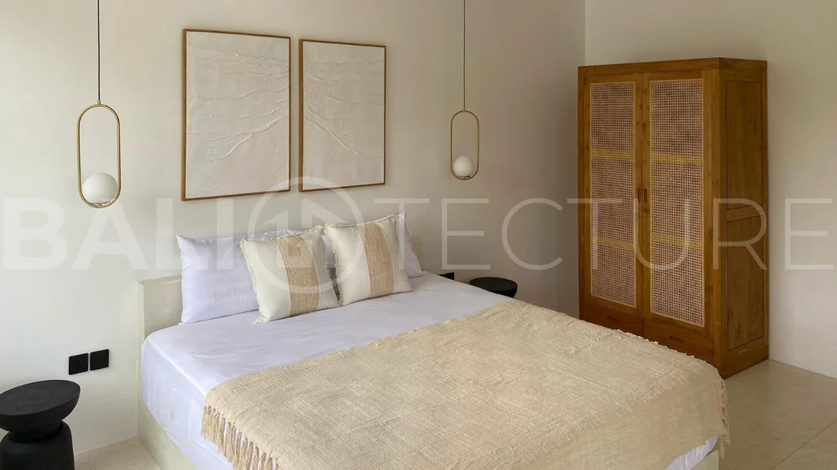 Modern 1-bedroom villa for sale in Balangan featuring a private swimming pool, tropical garden, wooden pool deck, minimalist interiors, and a peaceful residential setting near Balangan Beach.