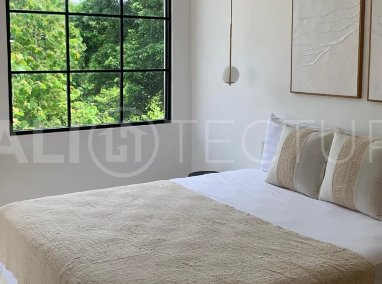 Modern 1-bedroom villa for sale in Balangan featuring a private swimming pool, tropical garden, wooden pool deck, minimalist interiors, and a peaceful residential setting near Balangan Beach.