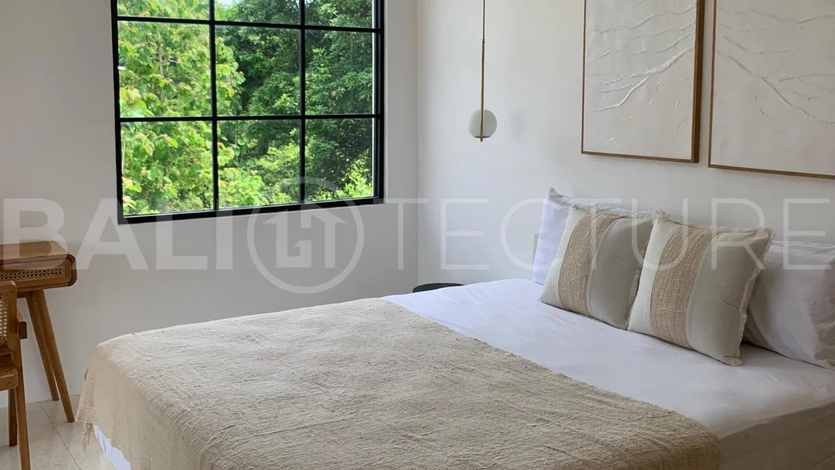 Modern 1-bedroom villa for sale in Balangan featuring a private swimming pool, tropical garden, wooden pool deck, minimalist interiors, and a peaceful residential setting near Balangan Beach.