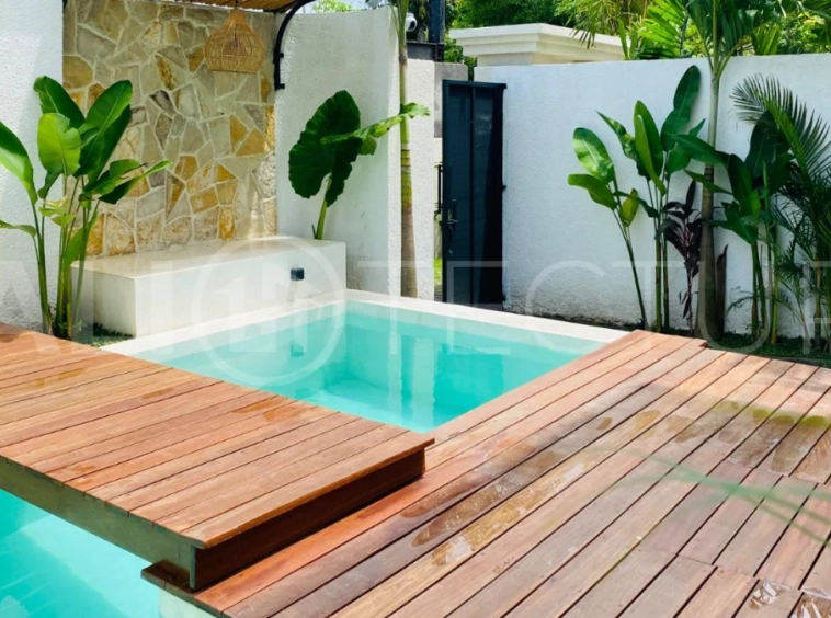 Modern 1-bedroom villa for sale in Balangan featuring a private swimming pool, tropical garden, wooden pool deck, minimalist interiors, and a peaceful residential setting near Balangan Beach.
