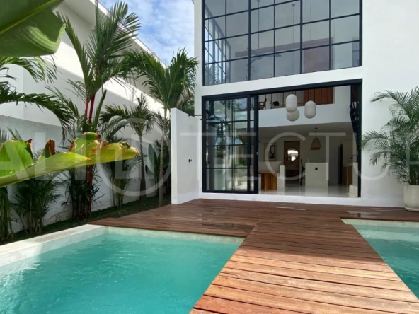 Modern 1-bedroom villa for sale in Balangan featuring a private swimming pool, tropical garden, wooden pool deck, minimalist interiors, and a peaceful residential setting near Balangan Beach.
