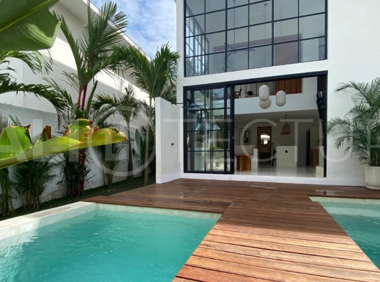 Modern 1-bedroom villa for sale in Balangan featuring a private swimming pool, tropical garden, wooden pool deck, minimalist interiors, and a peaceful residential setting near Balangan Beach.