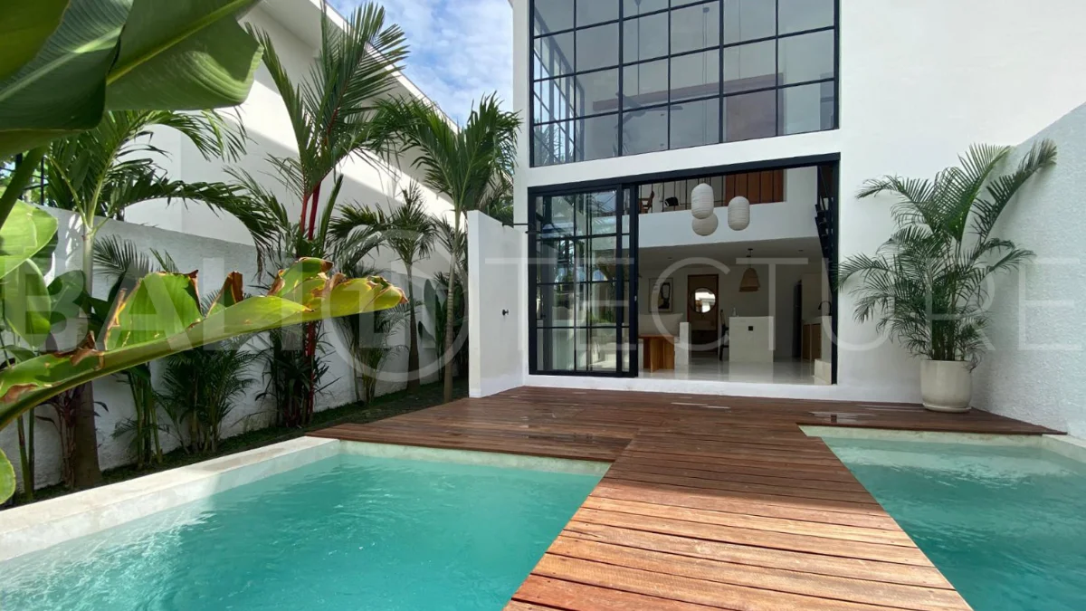 Modern 1-bedroom villa for sale in Balangan featuring a private swimming pool, tropical garden, wooden pool deck, minimalist interiors, and a peaceful residential setting near Balangan Beach.