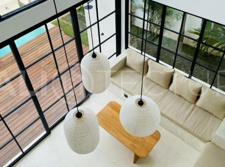 Modern 1-bedroom villa for sale in Balangan featuring a private swimming pool, tropical garden, wooden pool deck, minimalist interiors, and a peaceful residential setting near Balangan Beach.
