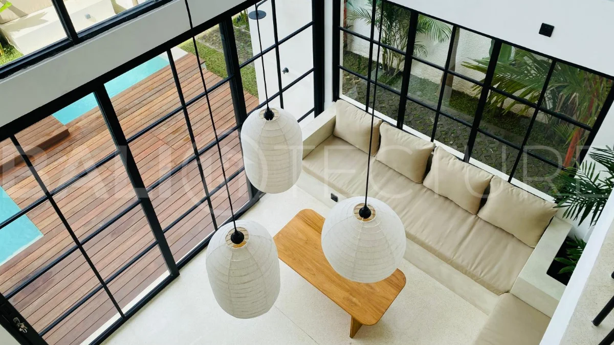 Modern 1-bedroom villa for sale in Balangan featuring a private swimming pool, tropical garden, wooden pool deck, minimalist interiors, and a peaceful residential setting near Balangan Beach.