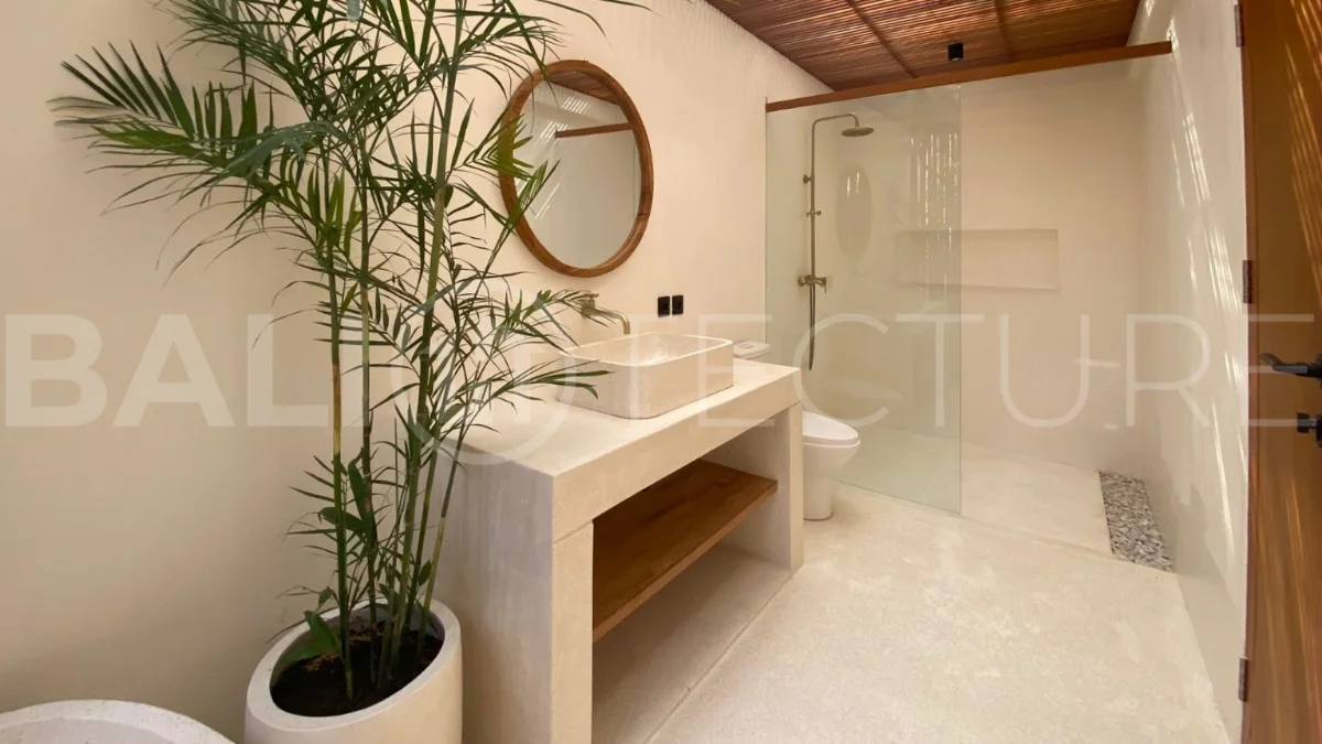 Modern 1-bedroom villa for sale in Balangan featuring a private swimming pool, tropical garden, wooden pool deck, minimalist interiors, and a peaceful residential setting near Balangan Beach.