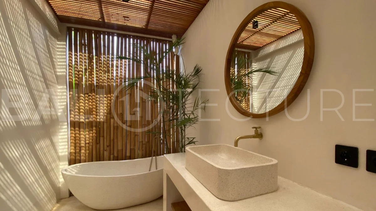 Modern 1-bedroom villa for sale in Balangan featuring a private swimming pool, tropical garden, wooden pool deck, minimalist interiors, and a peaceful residential setting near Balangan Beach.