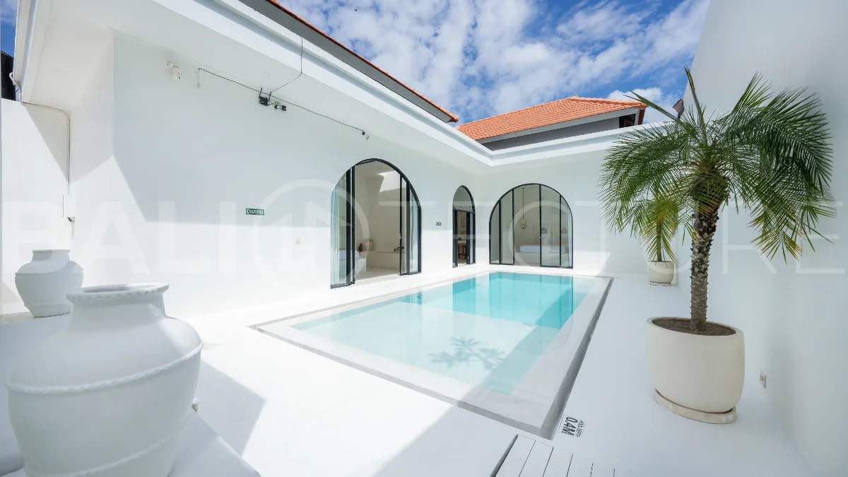 Newly built modern minimalist 2-bedroom villa in Padonan, Canggu, featuring a private swimming pool, tropical landscaping, enclosed living areas, and a contemporary tropical design.
