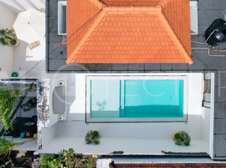 Newly built modern minimalist 2-bedroom villa in Padonan, Canggu, featuring a private swimming pool, tropical landscaping, enclosed living areas, and a contemporary tropical design.