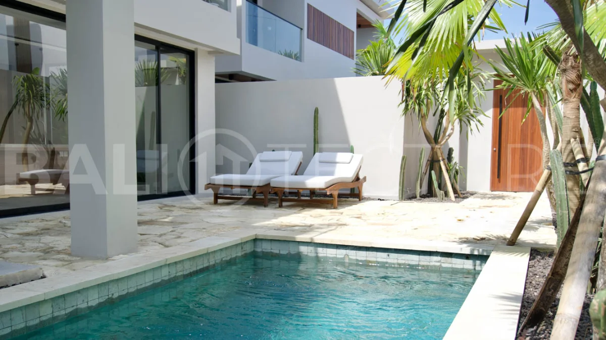 Modern 2 Bedroom Villa for Sale in Ungasan featuring contemporary Mediterranean and industrial inspired architecture, enclosed living and dining areas, a fully equipped kitchen with island, two ensuite bedrooms with private balconies, a private swimming pool, landscaped garden, and covered parking. Situated on 180 sqm of land with a 27 year leasehold, just minutes from Melasti Beach, New Kuta Golf, Savaya, and Bingin.
