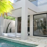 Modern 2 Bedroom Villa for Sale in Ungasan featuring contemporary Mediterranean and industrial inspired architecture, enclosed living and dining areas, a fully equipped kitchen with island, two ensuite bedrooms with private balconies, a private swimming pool, landscaped garden, and covered parking. Situated on 180 sqm of land with a 27 year leasehold, just minutes from Melasti Beach, New Kuta Golf, Savaya, and Bingin.