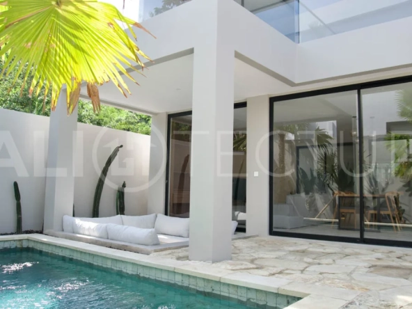 Modern 2 Bedroom Villa for Sale in Ungasan featuring contemporary Mediterranean and industrial inspired architecture, enclosed living and dining areas, a fully equipped kitchen with island, two ensuite bedrooms with private balconies, a private swimming pool, landscaped garden, and covered parking. Situated on 180 sqm of land with a 27 year leasehold, just minutes from Melasti Beach, New Kuta Golf, Savaya, and Bingin.