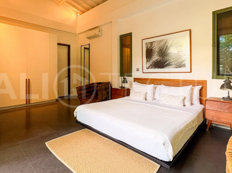 Modern four-bedroom villa in Tumbak Bayuh, Pererenan, featuring a private 12-meter swimming pool, tropical garden, double-height living area, spacious outdoor terrace, and contemporary furnished interiors on a 5.5-are plot.
