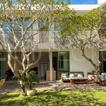 Modern four-bedroom villa in Tumbak Bayuh, Pererenan, featuring a private 12-meter swimming pool, tropical garden, double-height living area, spacious outdoor terrace, and contemporary furnished interiors on a 5.5-are plot.