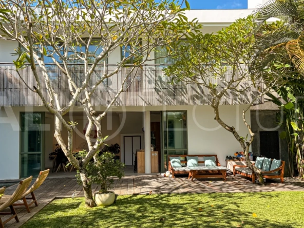 Modern four-bedroom villa in Tumbak Bayuh, Pererenan, featuring a private 12-meter swimming pool, tropical garden, double-height living area, spacious outdoor terrace, and contemporary furnished interiors on a 5.5-are plot.