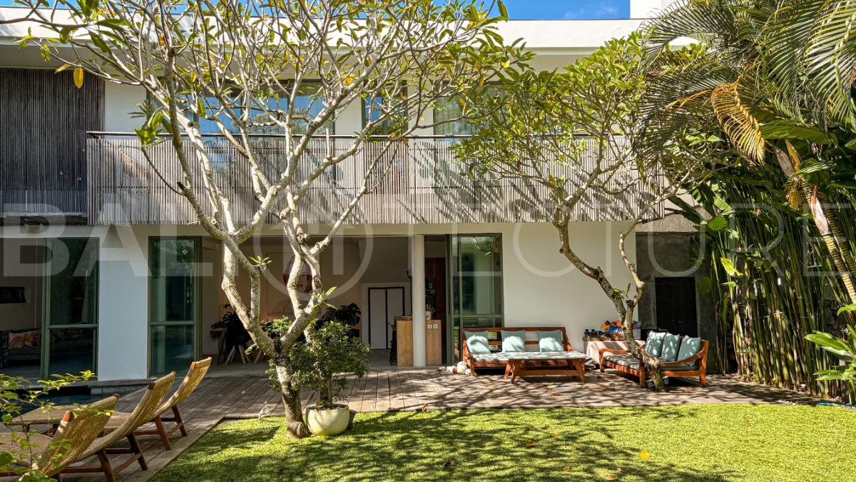 Modern four-bedroom villa in Tumbak Bayuh, Pererenan, featuring a private 12-meter swimming pool, tropical garden, double-height living area, spacious outdoor terrace, and contemporary furnished interiors on a 5.5-are plot.