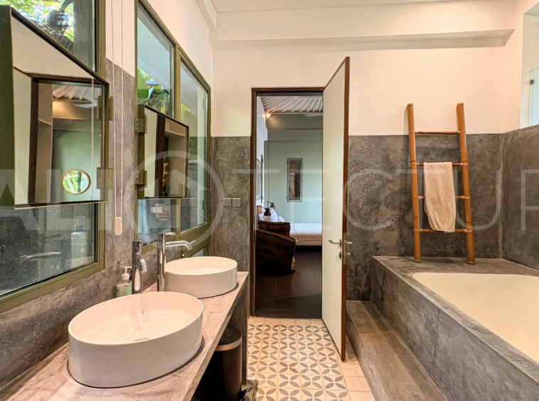 Modern four-bedroom villa in Tumbak Bayuh, Pererenan, featuring a private 12-meter swimming pool, tropical garden, double-height living area, spacious outdoor terrace, and contemporary furnished interiors on a 5.5-are plot.