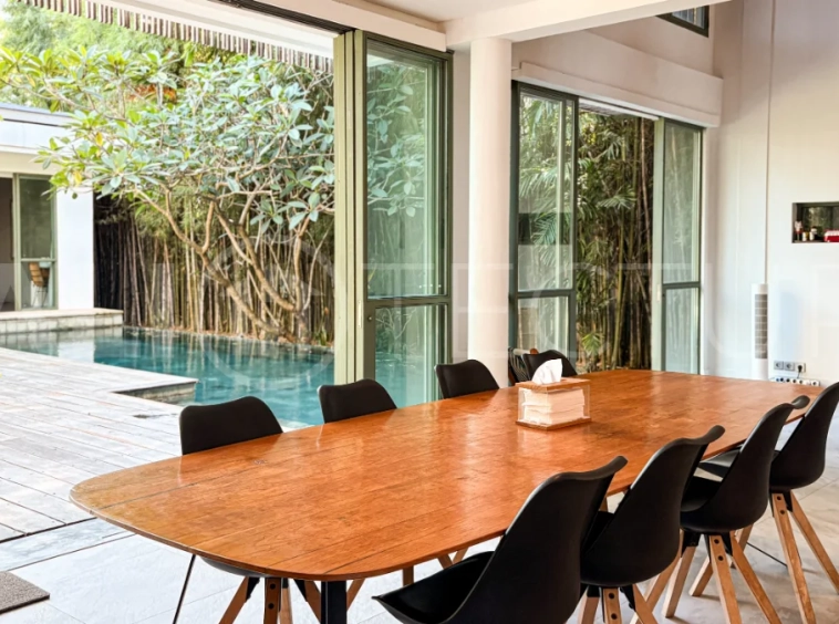 Modern four-bedroom villa in Tumbak Bayuh, Pererenan, featuring a private 12-meter swimming pool, tropical garden, double-height living area, spacious outdoor terrace, and contemporary furnished interiors on a 5.5-are plot.