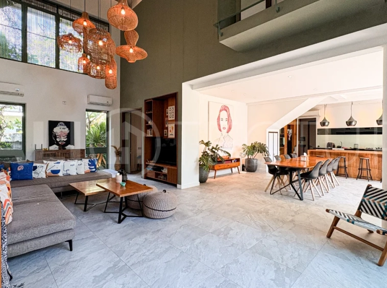 Modern four-bedroom villa in Tumbak Bayuh, Pererenan, featuring a private 12-meter swimming pool, tropical garden, double-height living area, spacious outdoor terrace, and contemporary furnished interiors on a 5.5-are plot.