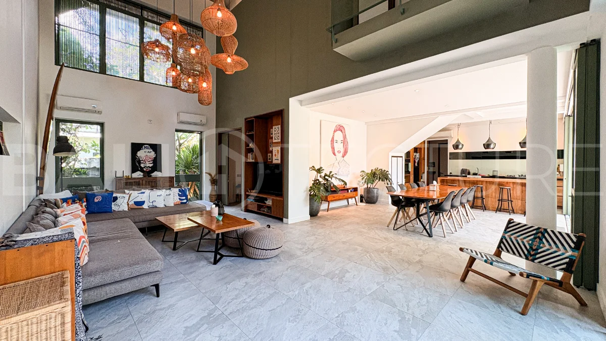 Modern four-bedroom villa in Tumbak Bayuh, Pererenan, featuring a private 12-meter swimming pool, tropical garden, double-height living area, spacious outdoor terrace, and contemporary furnished interiors on a 5.5-are plot.