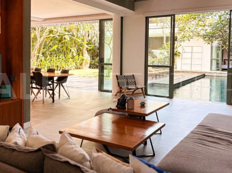 Modern four-bedroom villa in Tumbak Bayuh, Pererenan, featuring a private 12-meter swimming pool, tropical garden, double-height living area, spacious outdoor terrace, and contemporary furnished interiors on a 5.5-are plot.