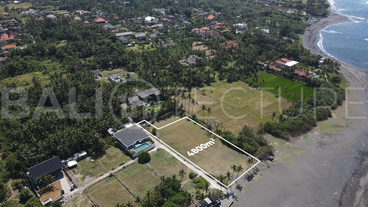 4,800 m² freehold beachfront land for sale in Saba Beach, Bali, directly overlooking the black-sand shoreline in a tranquil and undeveloped coastal setting.