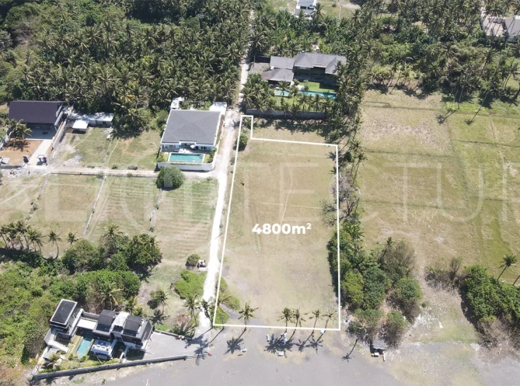 4,800 m² freehold beachfront land for sale in Saba Beach, Bali, directly overlooking the black-sand shoreline in a tranquil and undeveloped coastal setting.