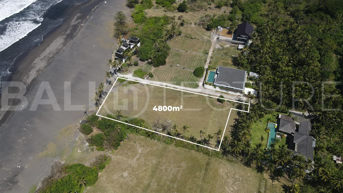 4,800 m² freehold beachfront land for sale in Saba Beach, Bali, directly overlooking the black-sand shoreline in a tranquil and undeveloped coastal setting.