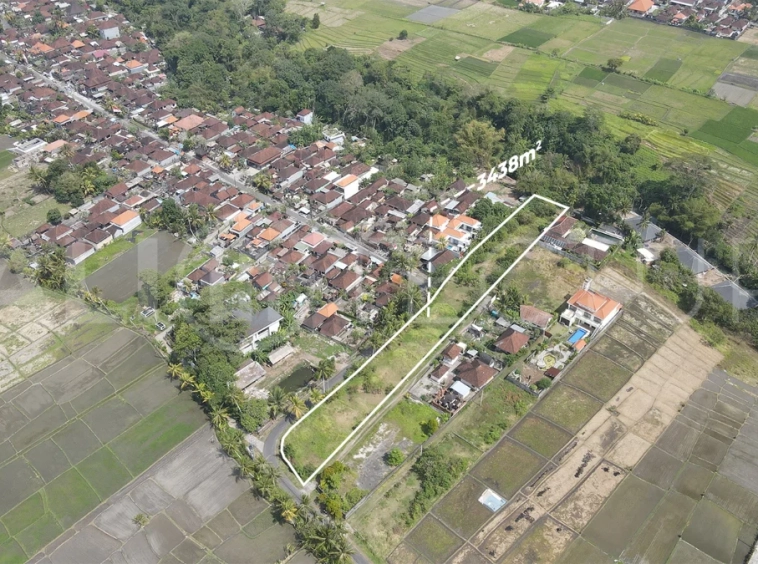 3,438 sqm east-facing riverside leasehold land in Kaba Kaba, Bali, surrounded by protected green-zone rice fields with panoramic river, rice terrace, and mountain views, featuring 4-meter asphalt road access and ideal for villa development.