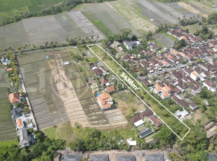3,438 sqm east-facing riverside leasehold land in Kaba Kaba, Bali, surrounded by protected green-zone rice fields with panoramic river, rice terrace, and mountain views, featuring 4-meter asphalt road access and ideal for villa development.