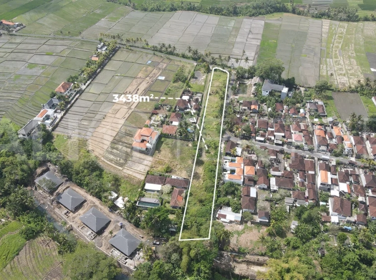 3,438 sqm east-facing riverside leasehold land in Kaba Kaba, Bali, surrounded by protected green-zone rice fields with panoramic river, rice terrace, and mountain views, featuring 4-meter asphalt road access and ideal for villa development.